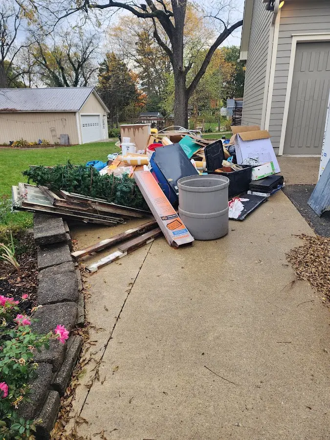 Dumpster being loaded with debris for Estate Cleanout Dumpster Rental in East Milton